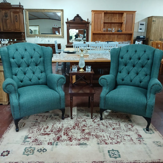 Deep buttoned green wingback chairs